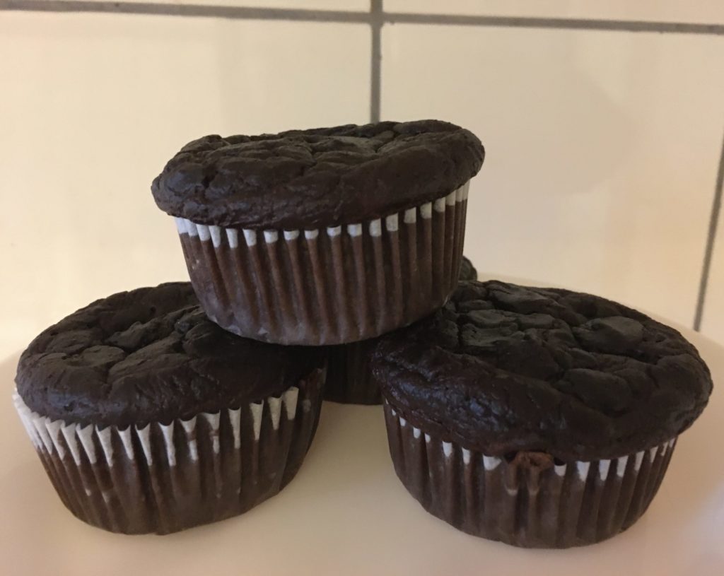 4 healthy chocolate muffins stacked in a pyramid shape