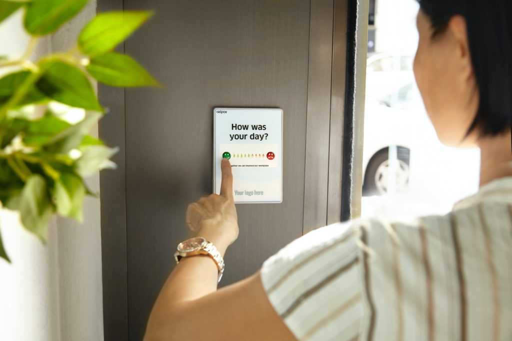 Woman pressing a button giving feedback on how her day was.